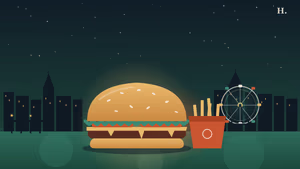 Best burgers in Kemah TX: a stacked burger with the Galveston Bay waterfront and pier lights at night